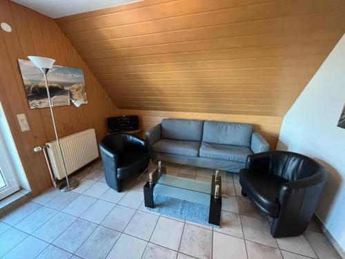a living room with a couch and two chairs at Doris in Norddeich