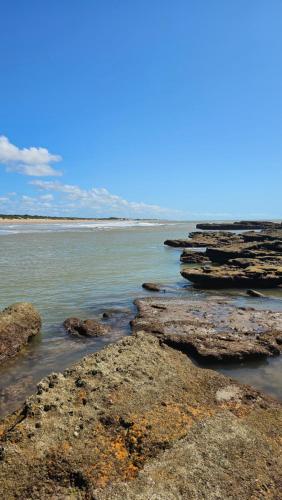 a group of rocks in the water on a beach at Chalés Vila Irerê Itaúnas in Itaúnas