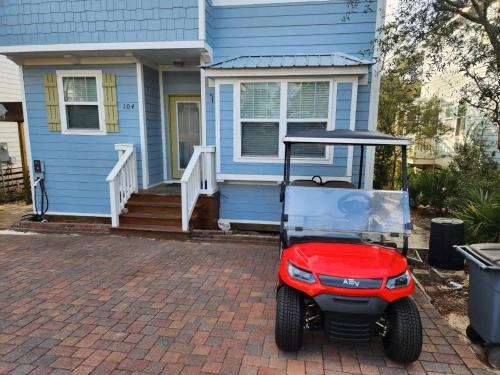 a golf cart parked in front of a blue house at Beautiful 4 bedroom near Rosemary Beach! in Inlet Beach