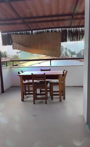 a ping pong table and two chairs on a patio at Triplex Flecheiras in Flecheiras