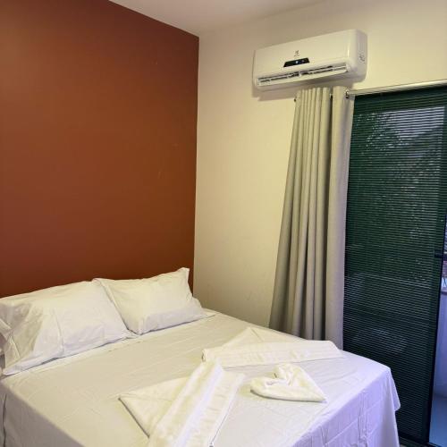 a bedroom with a bed with a air conditioner at Triplex Flecheiras in Flecheiras