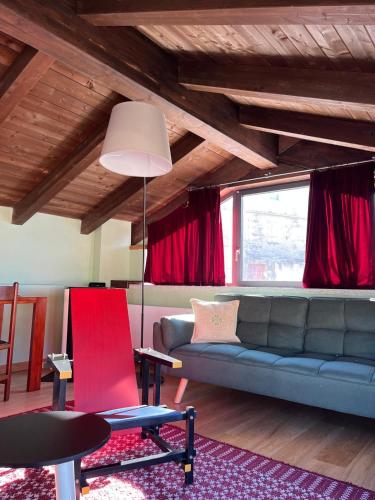 a living room with a blue couch and a red chair at Casa Ziranu Sa Domo e su Cantaru in Orani