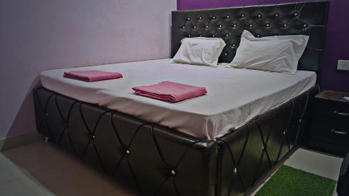 a large bed with two pink towels on it at Shri Rameshwaram Dham Ashram in Naimishāranya