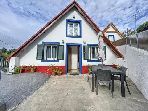 a house with a table and chairs in front of it at Casa do Avô in Santana
