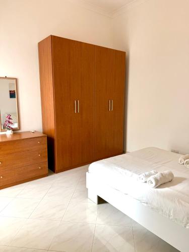 a bedroom with a bed and a wooden cabinet at Pembroke Parkside Maisonette in Pembroke 