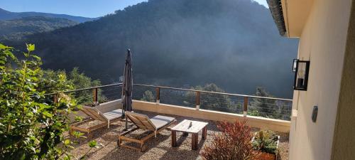 two chairs and a table on a balcony with a view at Chambres d hôtes les Romarins in Cantaron