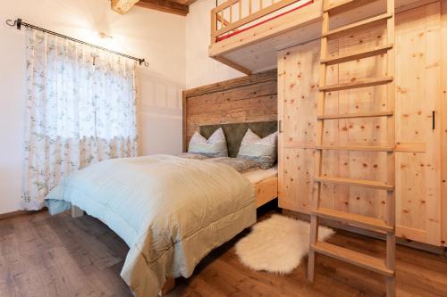 a bedroom with a bed and a wooden wall at Walker Chalet in Rettenbach