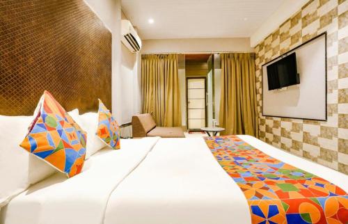 una habitación de hotel con una cama y un televisor en Hotel Silverkey International - Olive, en Mathura