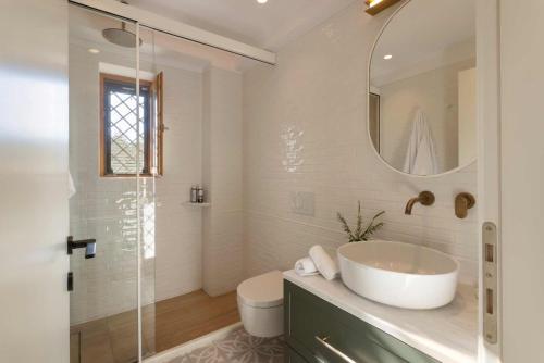 a white bathroom with a sink and a mirror at OD Luxury Villa in Pylos