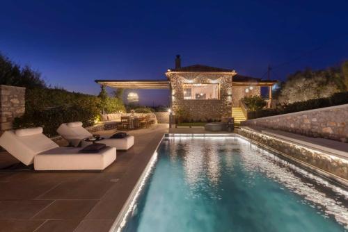 a backyard with a swimming pool at night at OD Luxury Villa in Pylos