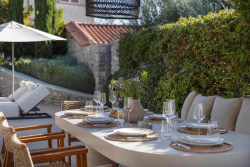 a white table with plates and glasses on a patio at OD Luxury Villa in Pylos