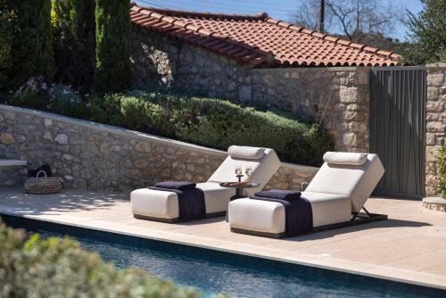two chairs and a table next to a pool at OD Luxury Villa in Pylos