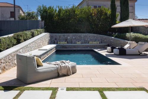 a pool with a couch and chairs and an umbrella at OD Luxury Villa in Pylos