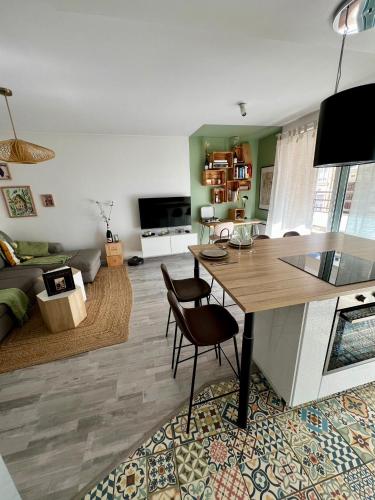 un salon avec une table et des chaises dans une pièce dans l'établissement Clovis - Hypercentre avec balcon et parking, à Reims