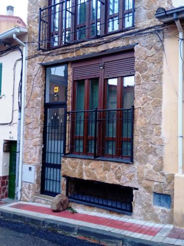 a building with a door and a balcony at Lujo en la Sierra in Becerril de la Sierra