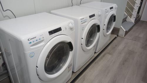 three washing machines are lined up in a laundry room at Lujo en la Sierra in Becerril de la Sierra