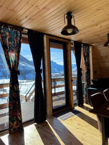 a room with large windows with a view of a mountain at Kazbegi Inn Cottages in Stepantsminda