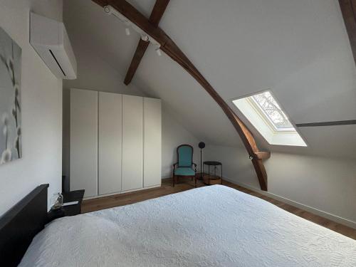 an attic bedroom with a bed and a skylight at Prachtig en ruim appartement in centrum Lochem in Lochem