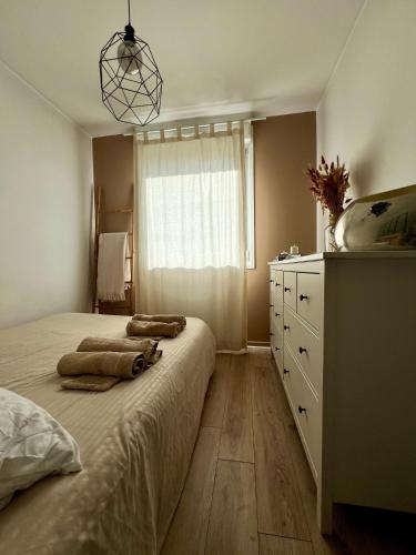 une chambre avec un lit, une commode et une fenêtre dans l'établissement Clovis - Hypercentre avec balcon et parking, à Reims