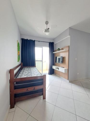 a bedroom with a bed in a room with a window at Apto no Itaguá - Varanda Gourmet e Lazer completo in Ubatuba