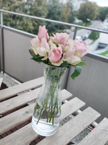 a vase filled with pink roses sitting on a table at Business & Leisure Apartment in Ingolstadt
