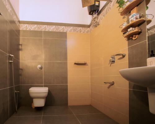 a bathroom with a toilet and a sink at Lakefront 2BHK villa I Cozy A-frame balcony deck & BBQ grill in Kollam