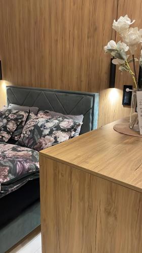 a room with a bed and a table with flowers at Lux Dabich 2 in Novi Sad