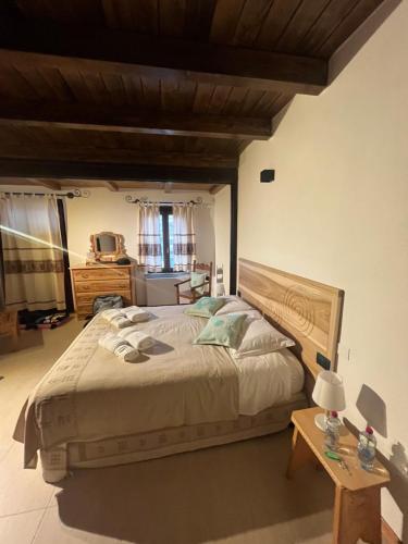 a bedroom with a large bed and a table at Casa Ziranu Sa Domo e su Cantaru in Orani