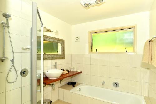 baño con bañera, lavabo y ventana en Avalon Resort, en Kerikeri