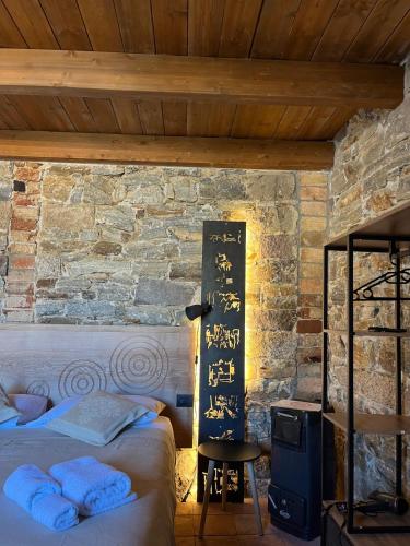 a bedroom with a bed and a stone wall at Casa Ziranu Sa Domo e su Cantaru in Orani