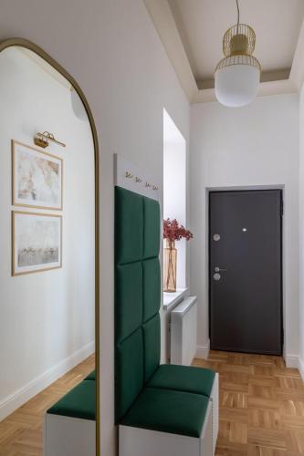a room with a mirror and a green chair at GOLDENGREEn in Sibiu
