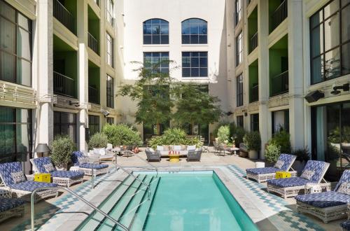 a courtyard with chairs and a swimming pool in a building at The Aster in Los Angeles