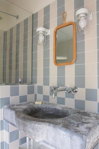 La salle de bains est pourvue d'un lavabo en marbre et d'un miroir. dans l'établissement Le charme au centre du village, à Ménerbes