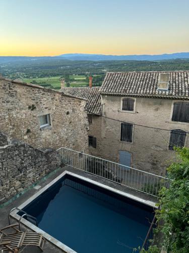 une grande piscine devant un immeuble dans l'établissement Le charme au centre du village, à Ménerbes