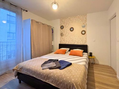 - une chambre dotée d'un lit avec des oreillers orange dans l'établissement La Tour - Tout confort - Hypercentre - Balcon #SirDest, à Franconville