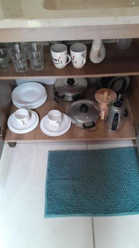 a shelf with plates and cups and dishes on it at Trento Chalés in Nova Trento