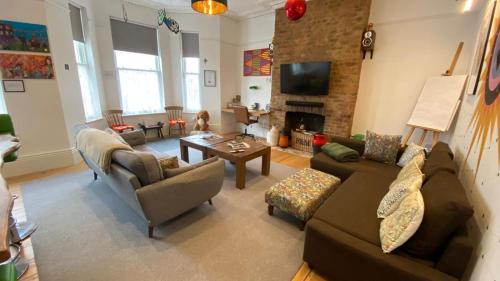 a living room with two couches and a fireplace at Church Retreat - A Magnificent Seaside Apartment-Award Winning in Hastings
