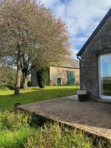 una casa in pietra con un albero nel cortile di Maison de caractère en Bretagne a La Pellerine