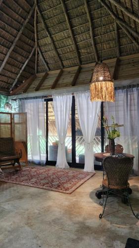 a room with a bed with white curtains and a chandelier at Boho villas and spa in El Valle