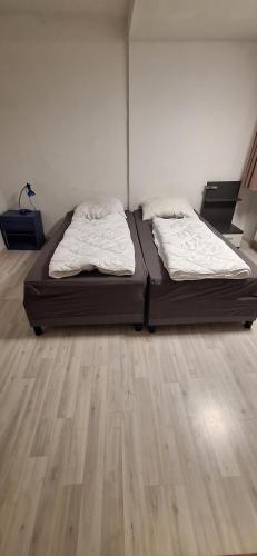 two beds in a room with a wooden floor at Blumenblick in Kirchhain