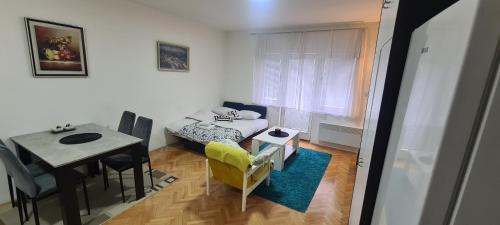 een woonkamer met een tafel en een eetkamer bij Vista Studio Apartment in Brčko