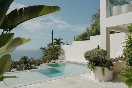 a swimming pool in a villa with a view of the ocean at Sky House Santa Teresa - Adults only in Santa Teresa Beach