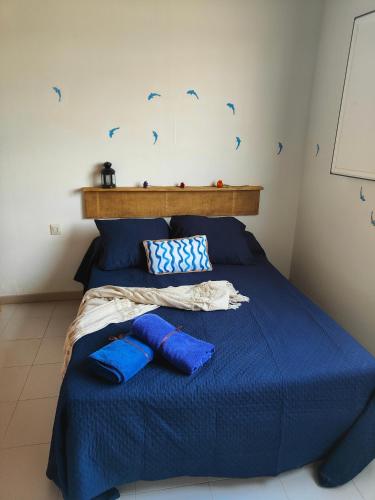 a bedroom with a blue bed with blue pillows at Casita Sofia in Caleta de Sebo