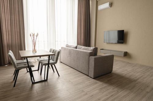 a living room with a couch and a table with chairs at REST INN apart hotel in Cherkasy