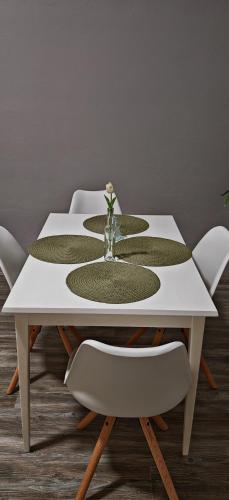 a white table with a flower vase on it at Old Town & New Style in Pécs