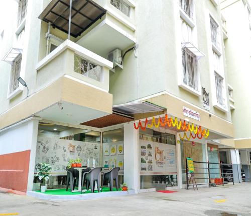 a store with tables and chairs in front of a building at Copper 11 Service Apartments -SB Road, Shivaji Nagar, Pune in Pune