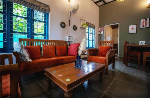a living room with a couch and a coffee table at Lakefront 2BHK villa I Cozy A-frame balcony deck & BBQ grill in Kollam