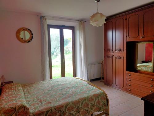 a bedroom with a bed and a tv and a window at La casa di Cleo in Castiglione del Lago