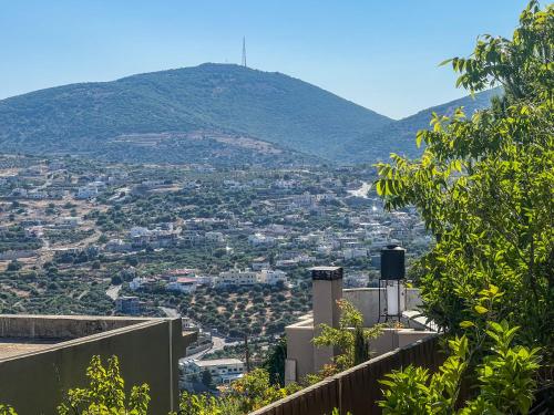 a view of a city with a mountain in the background at Lana's Guest House in Ḥurfeish