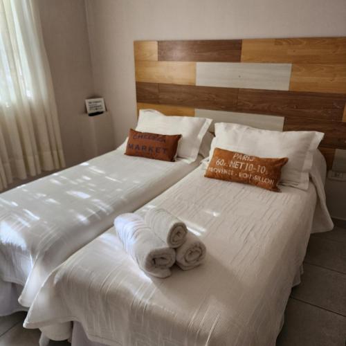 two beds in a hotel room with towels on them at La constancia in La Plata